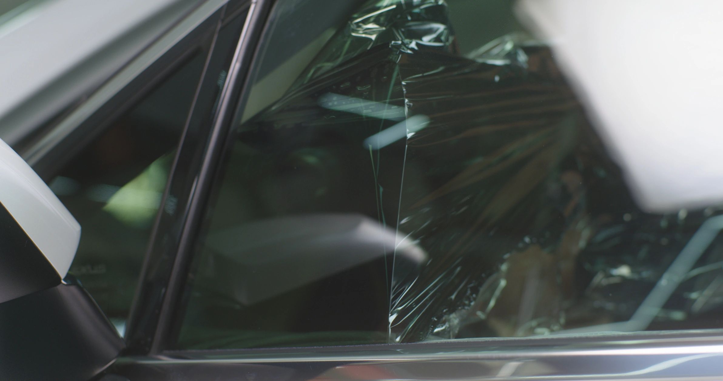 Technician cleaning a car window as part of interior detailing