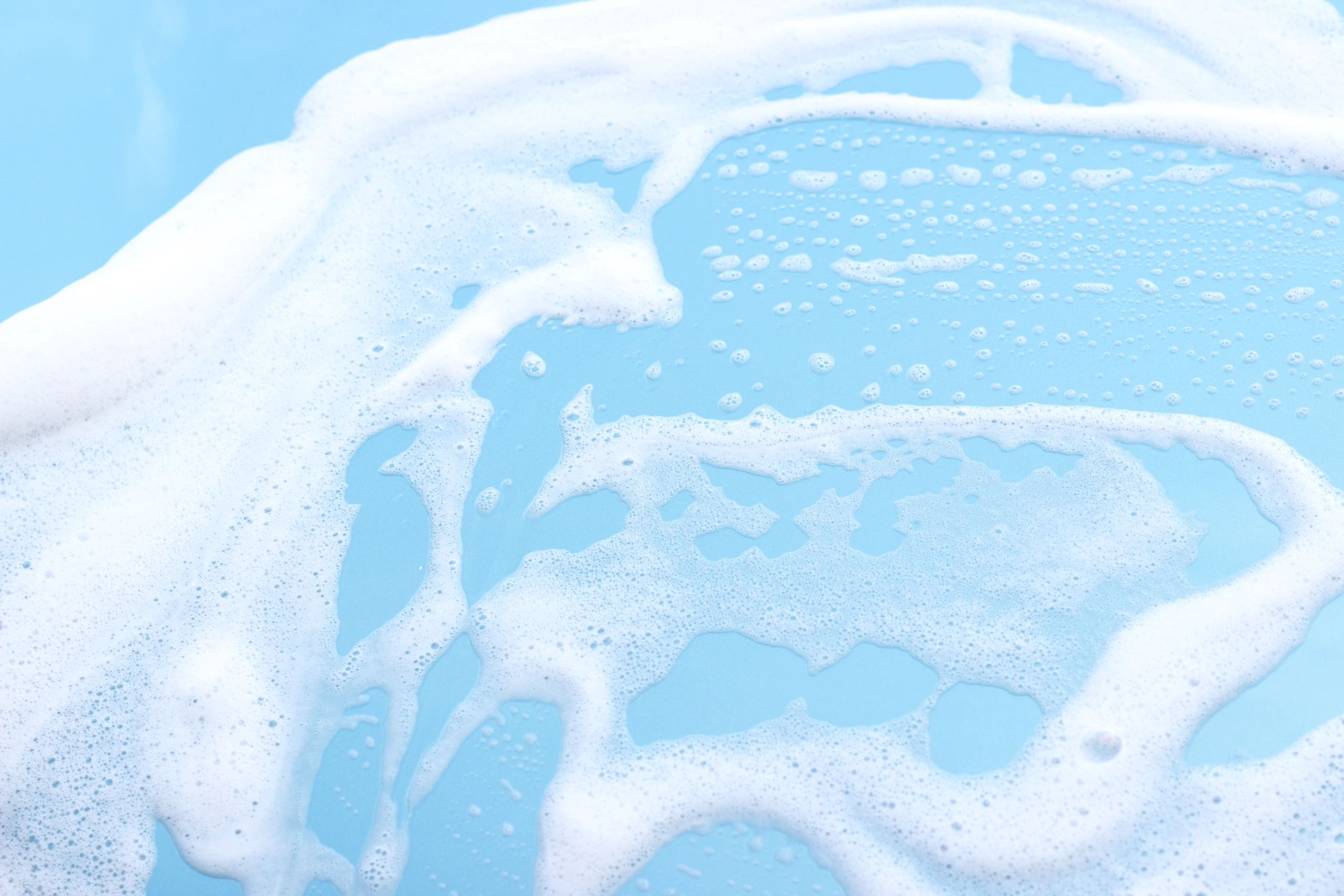 Close-up of foam on a car surface during washing