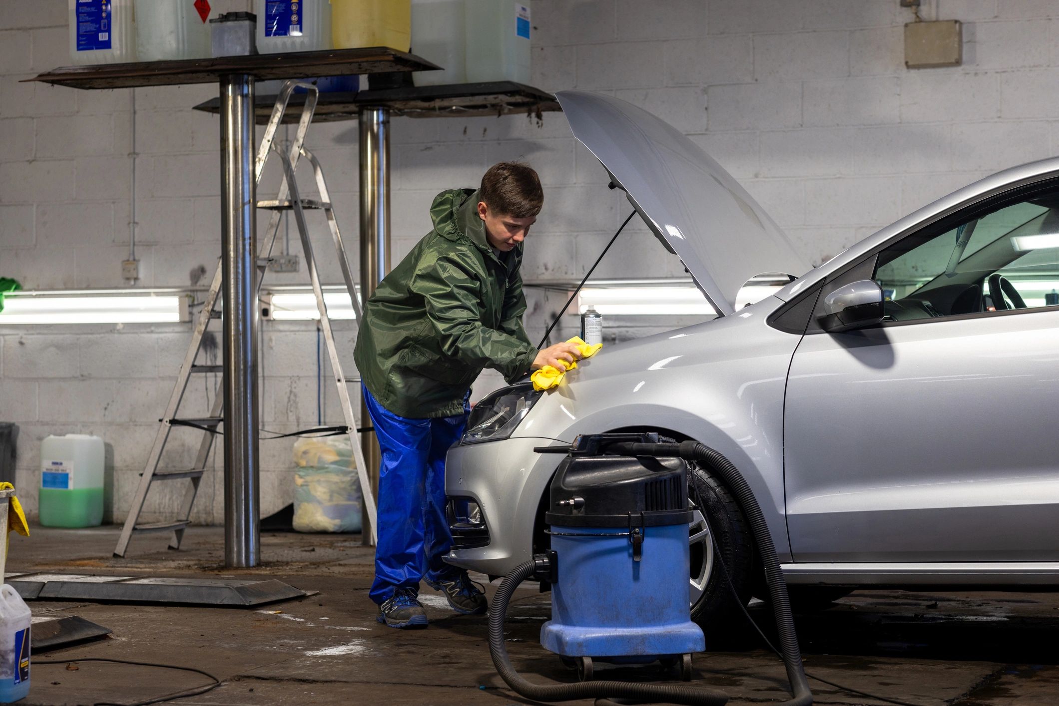 Detailer wiping the front of a car for a clean, glossy finish